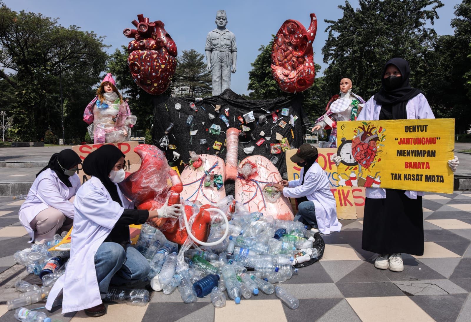 Aktivis lingkungan membentangkan poster saat aksi Plastic Free July 2025 di depan Gedung Negara Grahadi, Surabaya . Aksi damai yang menyerukan bahaya mikroplastik bagi kesehatan manusia itu dilakukan komunitas MARAPAIMA dan ECOTON dengan menyampaikan seju