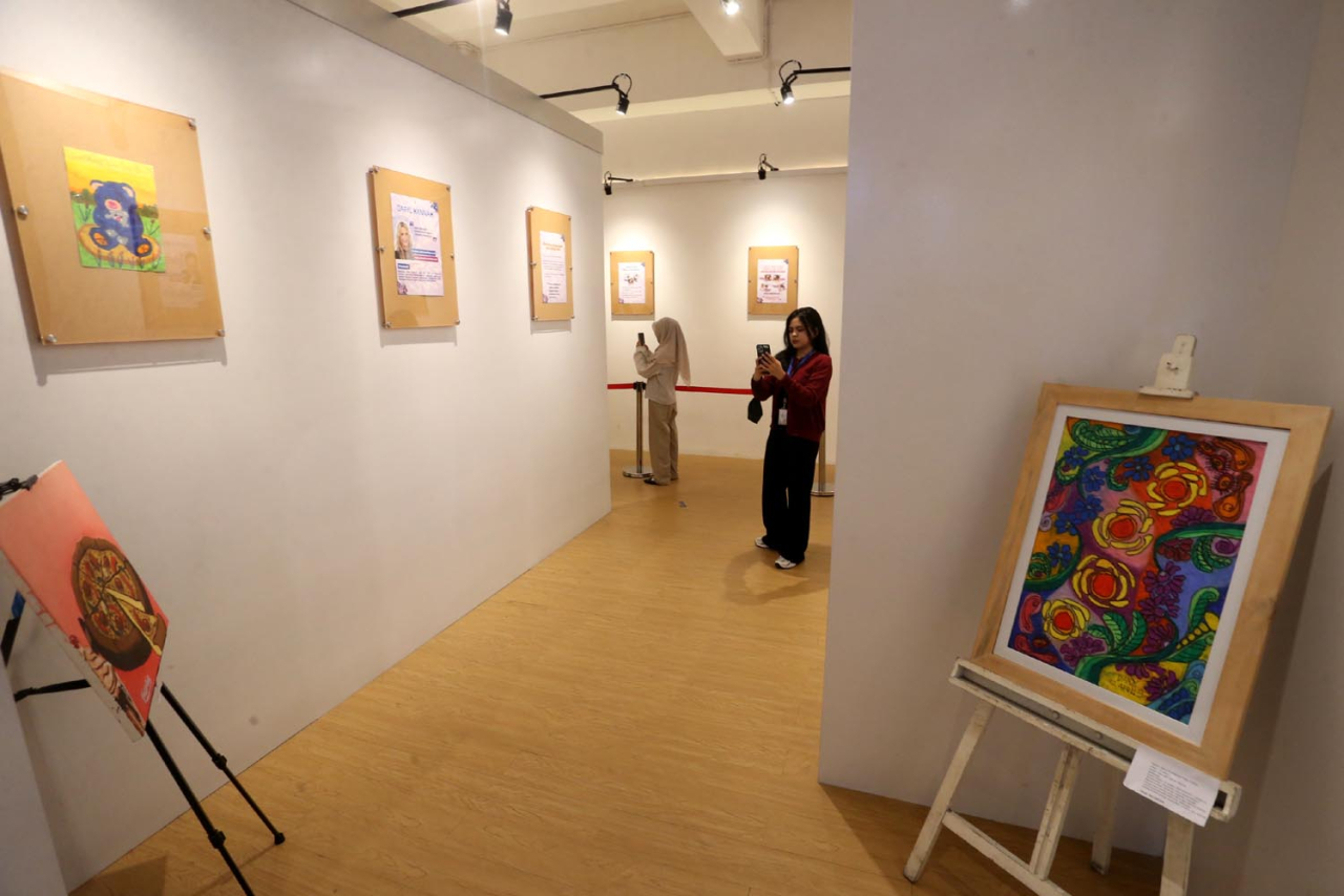 Pengujung mengamati lukisan karya anak autis di Malang Autism Center (MAC). Foto/RLD